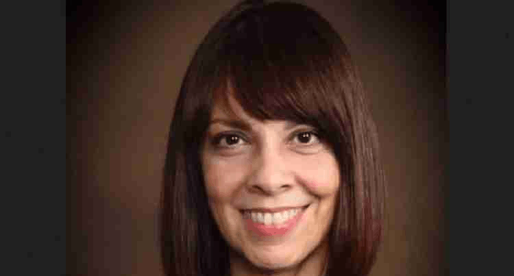 Una mujer de pelo medio corto sonrie