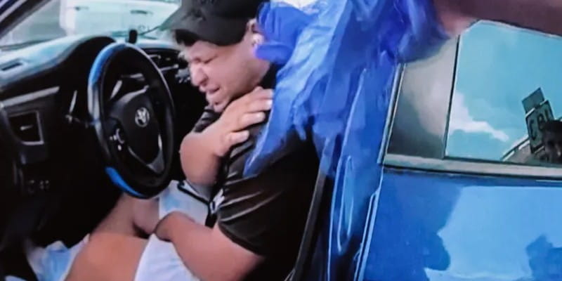 Un hombre se toca el hombro y hace un gesto de dolor
