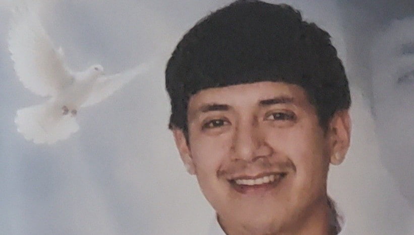 Una paloma blanca de fondo y un joven sonriendo